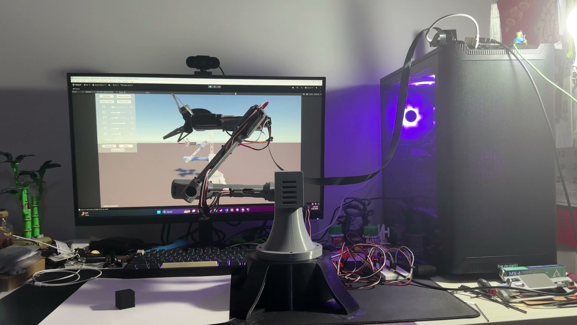 Physical robot arm pickup demonstration shown alongside its Unity digital twin poster