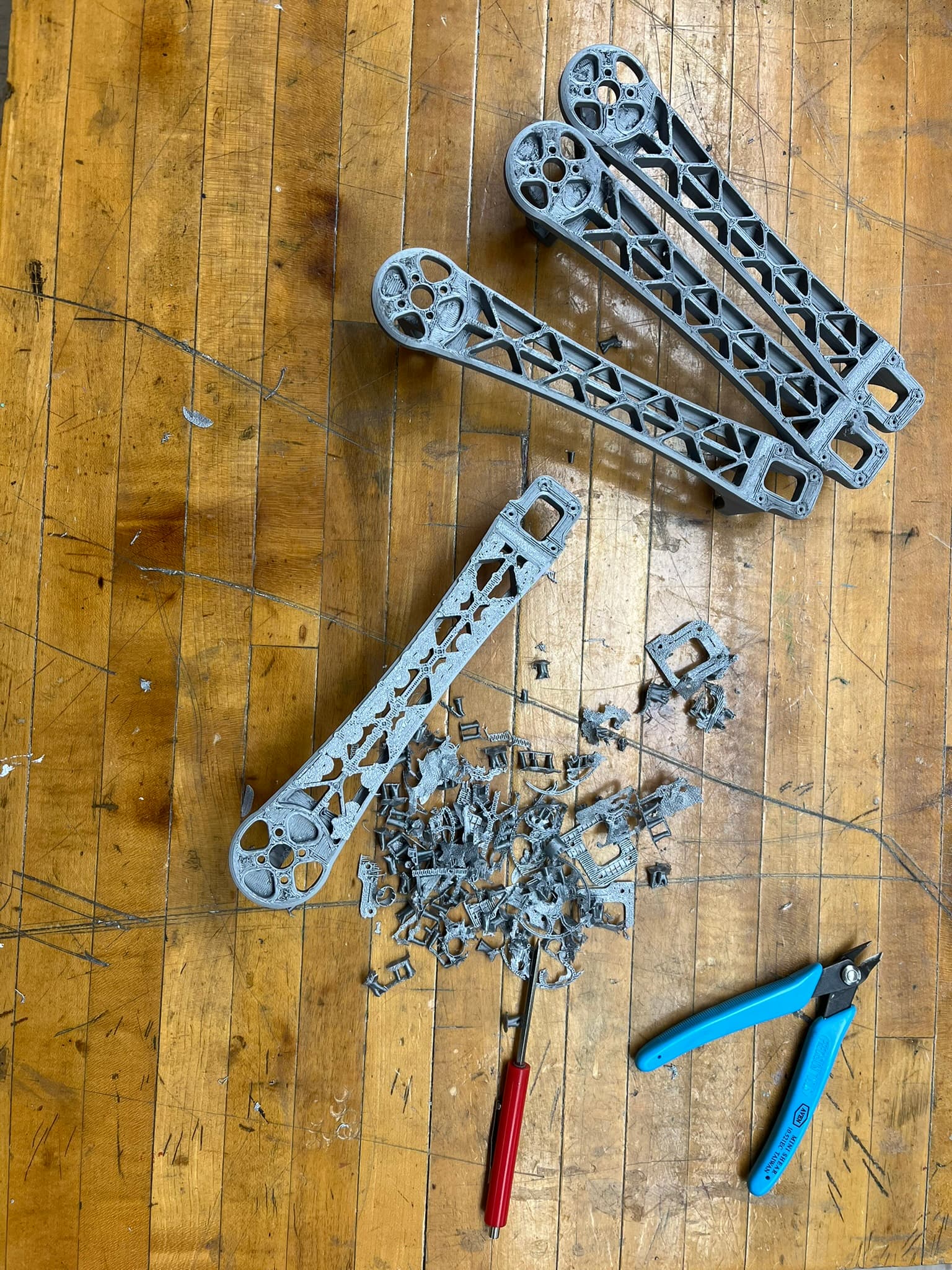 Nylon-CF lattice quadcopter arms and removed support material on a workshop table