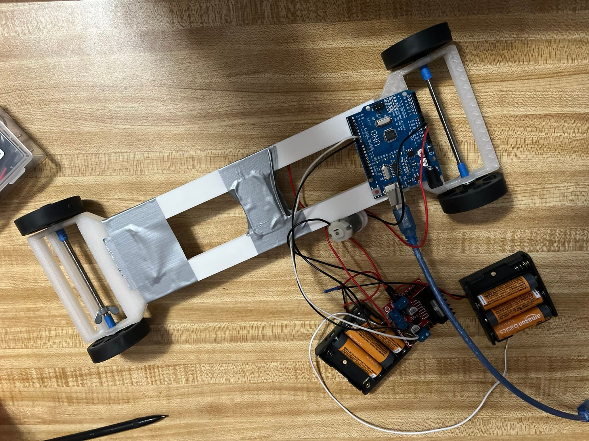 Landscape view of the early electric vehicle prototype with Arduino Uno, motor driver, and wiring